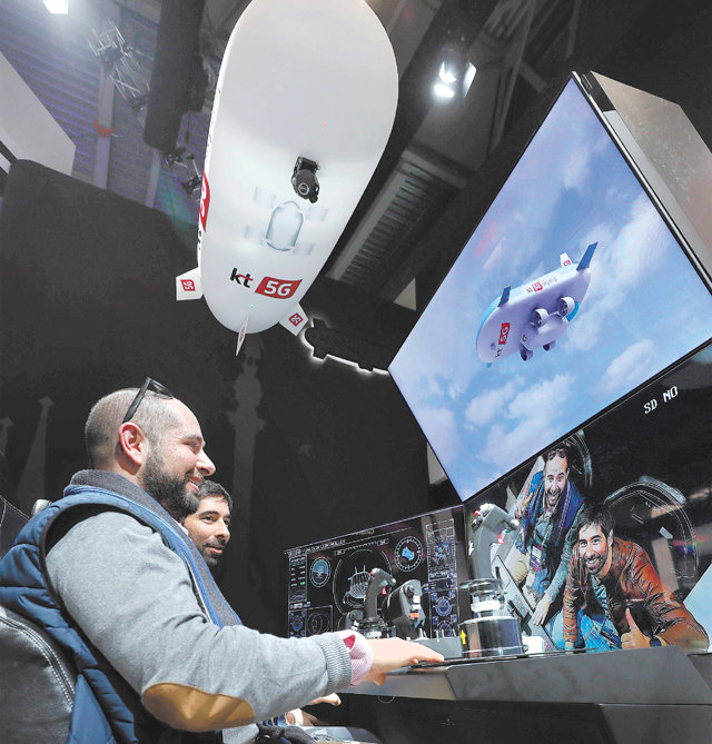 5G드론 띄워 통신 끊긴 지역 재난구조 25일(현지 시간) 개막한 스페인 MWC 2019 전시장의 KT 부스를 찾은 관람객들이 재난안전특화 플랫폼인 ‘5G 스카이십(무인 비행선)’ 체험을 하고 있다. 바르셀로나=사진공동취재단