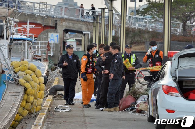 27일 오후 4시22분쭘 경북 포항시 북구 죽도동 동빈내항 바닷물에 신원을 알 수 없는 남성이 숨진 채 물에 떠 있다는 신고를 받고 출동한 포항해경 직원들이 시신을 인양한 후 소지품 등을 확인하고 있다.2019.2.27/뉴스1 © News1