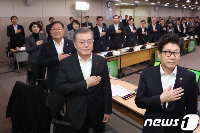 문재인 대통령이 18일 정부세종청사 환경부에서 2019년도 환경부 업무보고를 받기 앞서 국민의례를 하고 있다. 오른쪽부터 조명래 환경부 장관, 문 대통령, 김태년 더불어민주당 정책위의장. (청와대 제공) 2018.12.18/뉴스1