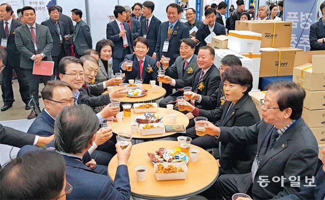 대구 북구 엑스코에서 지난달 26일 열린 대구시의 기업애로해결 박람회에서 권영진 대구시장을 비롯한 주요 내빈들이 VIP 라인투어 도중 치킨과 맥주를 즐기고 있다. 박광일 기자 light1@donga.com