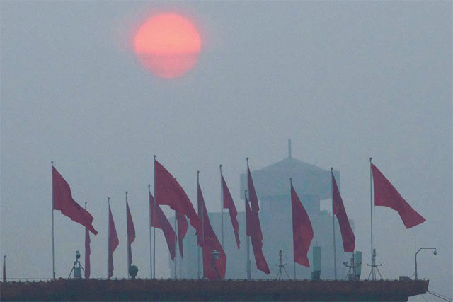 베이징 덮친 미세먼지 5일(현지 시간) 중국의 최대 정치 행사인 전국인민대표대회가 열리는 베이징 인민대회당 인근 건물 위에 붉은 깃발이 희뿌연 스모그에 뒤덮인 채 펄럭이고 있다. 베이징=AP 뉴시스