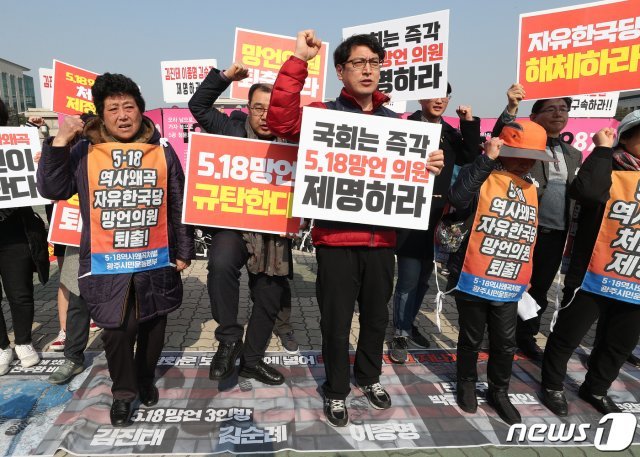 7일 오전 서울 여의도 국회 앞에서 열린 5·18 망언 자유한국당 국회의원 제명 촉구 기자회견에서 5·18 단체 회원들이 김진태·김순례·이종명 의원이 그려진 현수막을 발로 밟는 퍼포먼스를 하고 있다. 2019.3.7/뉴스1 © News1