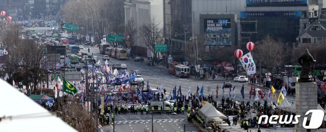 ‘박근혜 탄핵 2년’을 하루 앞둔 9일 오후 중구 봉래동 서울역 광장에서 열린 제112차 태극기 집회에서 참석자들이 태극기와 성조기를 흔들며 정부서울청사 앞으로 행진하고 있다. 2019.3.9/뉴스1 © News1