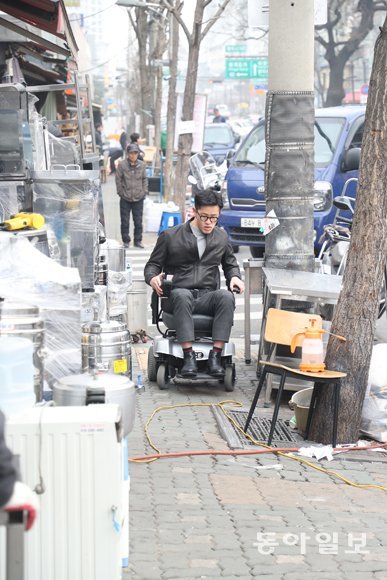 6일 오후 서울 중구 황학동 ‘주방거리’의 보도에서 본보 김자현 기자가 전동휠체어를 타고 이동하고 있다. 곳곳에 주방 집기들이 놓여 있어 이동에 어려움을 겪었다. 김동주 기자 zoo@donga.com