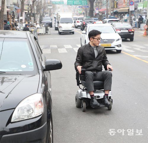 보도 끝자락에 있는 턱을 넘지 못해 결국 휠체어를 돌려 차도로 이동하는 모습. 김동주 기자 zoo@donga.com