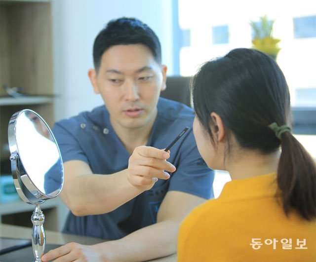 한 피부과 전문의가 다크서클로 찾아온 환자의 눈을 관찰하면서 진료를 하고 있다. 동아일보DB