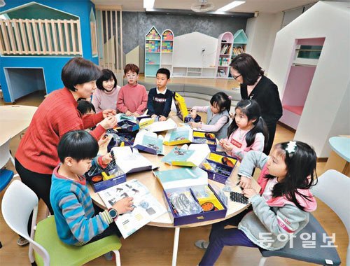 11일 서울 중구가 직영하는 흥인초등학교 돌봄교실에서 저녁을 먹은 학생들이 돌봄 전담 강사들과 과학교재를 활용해 로봇을 만들고 있다. 김동주 기자 zoo@donga.com