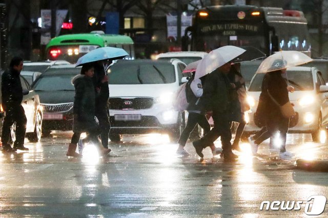 15일 오후 서울 종로구 광화문 네거리 일대에서 퇴근길 시민들이 우산을 쓰고 걸음을 재촉하고 있다.2019.3.15/뉴스1 © News1