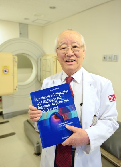 올해 한국 나이로 90세인 박용휘 에이치플러스 양지병원 핵의학센터 소장이 자신이 쓴 영문 책을 들고 있다. 그는 최근에도 영국 유명 의학 저널에 자신의 연구 논문을 실었다. 에이치플러스 양지병원 제공