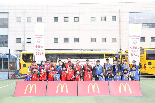 맥도날드의 ‘아빠와 함께하는 축구교실’ 킥오프에 참여한 가족들이 단체 사진을 찍고 있다. 사진제공｜맥도날드