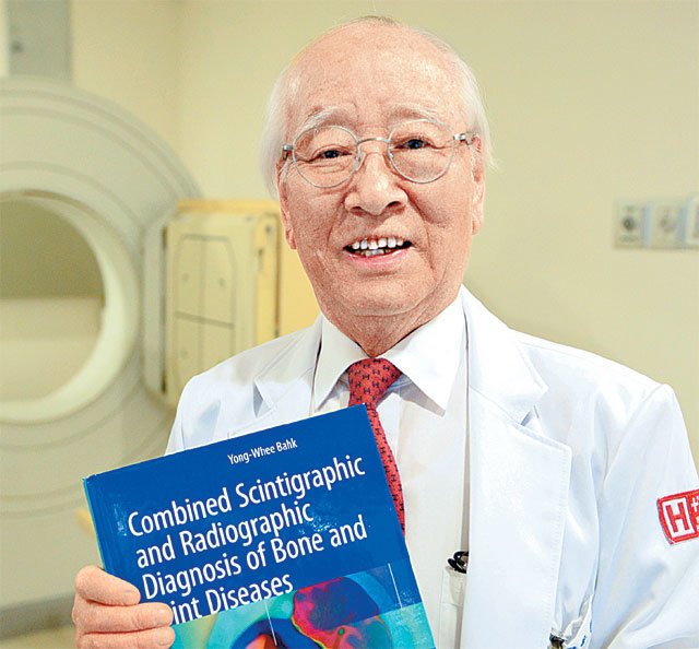 올해 한국 나이로 90세인 박용휘 에이치플러스 양지병원 핵의학센터 소장이 자신이 쓴 영문 책을 들고 있다. 에이치플러스 양지병원 제공
