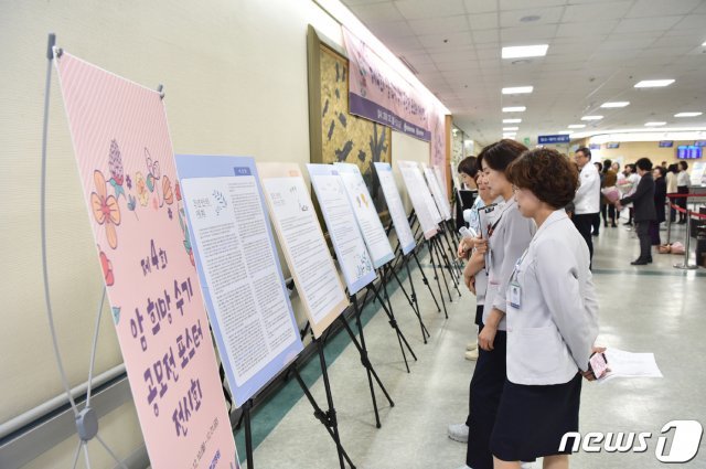 화순전남대병원 관계자들이 최근 병원에 전시된 암수기 작품을 읽고 있는 모습.(화순전남대병원 제공) 2019.3.19/뉴스1 © News1