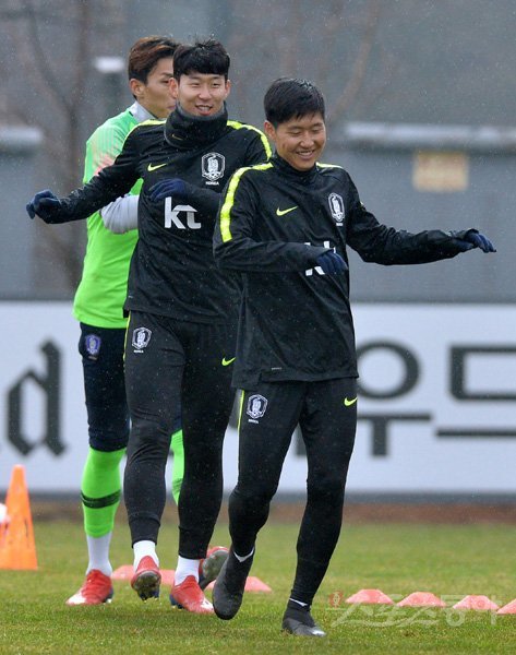 볼리비아(22일), 콜롬비아(26일)와 A매치 2연전을 앞둔 축구대표팀의 막내 이강인(오른쪽)이 20일 ‘캡틴’ 손흥민(가운데)과 함께 비를 맞으면서도 밝은 표정으로 파주 국가대표트레이닝센터(NFC)에서 몸을 풀고 있다. 소집 3일차 훈련이 진행된 이날, 파울루 벤투 감독은 손흥민을 최전방에 배치하고 이강인을 왼쪽 미드필더로 활용하며 경기력을 점검했다. 파주｜김민성 기자 marineboy@donga.com