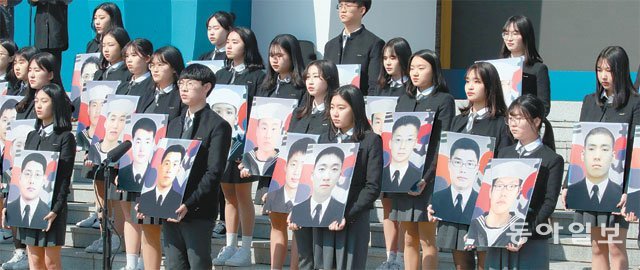 제4회 서해수호의 날을 맞은 22일 국립대전현충원에서 열린 기념식에서 학생들이 사진을 들고 서해 수호 55용사를 추모하고 있다. 대전=최혁중 기자 sajinman@donga.com