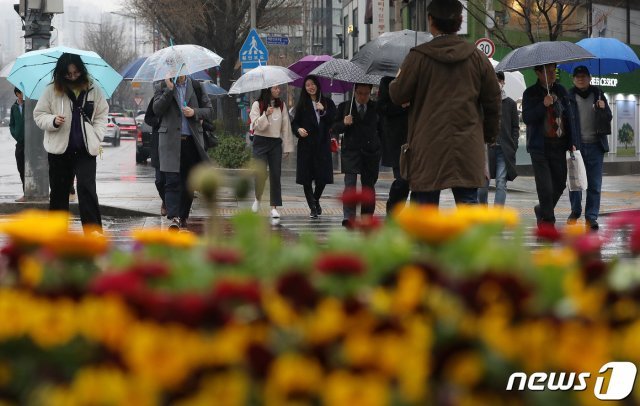 전국적으로 봄비가 내리고 있는 20일 오후 서울 세종대로 사거리에서 우산을 쓴 시민들이 발걸음을 옮기고 있다. © News1