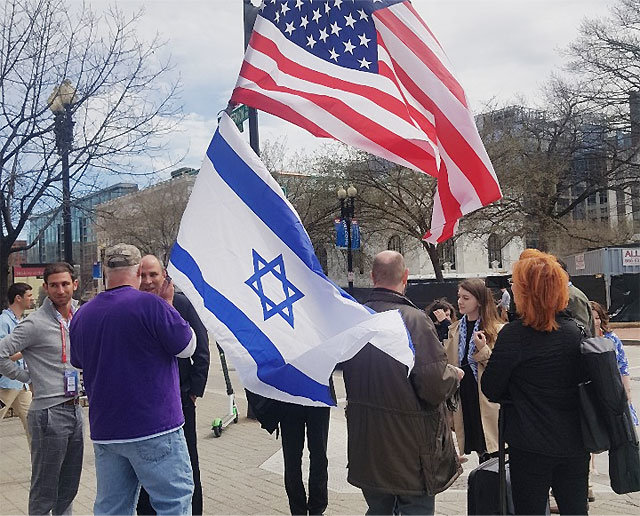 24일(현지 시간) 미국 워싱턴 컨벤션센터 앞에 모여든 AIPAC 참가자들이 이스라엘과 미국 국기를 함께 흔들고 있다. 이들은 행사장을 지나가는 미국인들에게 양국 관계의 중요성과 이스라엘 지원 필요성을 역설했다.