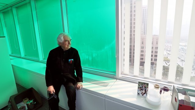 녹색으로 래핑된 동아미디어센터 6층에서 뷔렌이 창틀에 앉아 외부를 바라보고 있다.