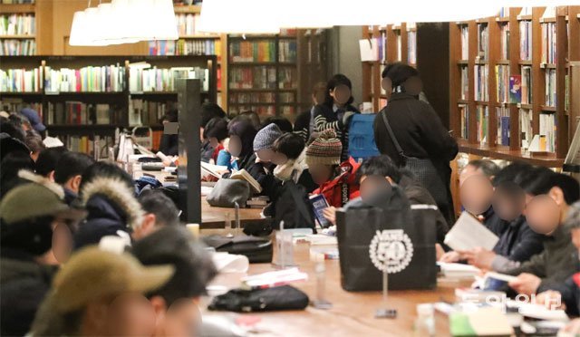 서울 종로구 교보문고 광화문 지점에 마련된 대형 테이블에서 독서하고 있는 시민들. 서점 곳곳에는 ‘한꺼번에 많은 도서를 쌓아두지 않기’ ‘저작권 보호를 위해 사진 촬영하지 않기’ 등의 에티켓을 안내하는 표지판이 세워져 있다. 동아일보DB