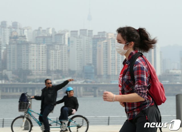 전국 대부분 지역이 미세먼지 농도 ‘나쁨’ 상태를 기록한 27일 오후 서울 여의도한강공원에서 마스크를 쓴 외국인이 달리기를 하고 있다. 2019.3.27/뉴스1