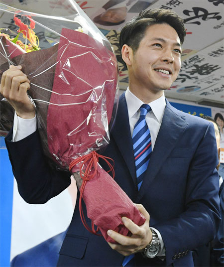 7일 일본 통일지방선거에서 홋카이도 지사로 뽑힌 스즈키 나오미치 전 유바리 시장이 당선을 축하하는 대형 꽃다발을 들고 있다. ‘야당 텃밭’인 홋카이도에서 연립 여당 후보로 당선된 그는 현 지사 중에서 최연소다. 아사히신문 제공