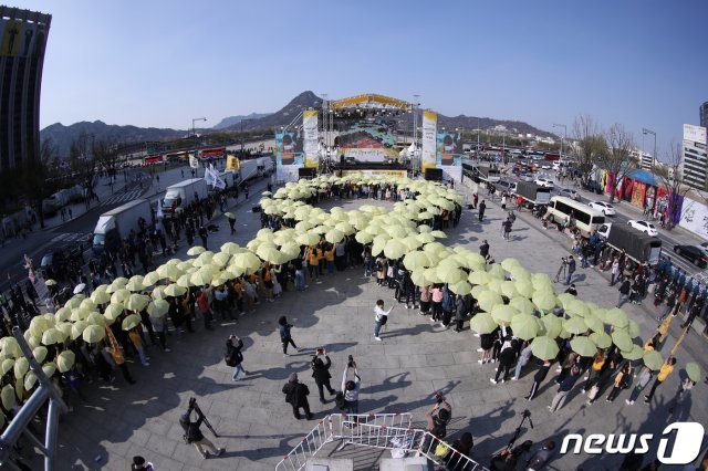 14일 오후 4시 16분에 서울 광화문광장에서 열린 세월호 참사 5주기 ‘잊지 않을게’ 대학생 대회에서 참가자들이 노란 우산으로 세월호 리본을 만드는 퍼포먼스를 하고 있다. 2019.4.13/뉴스1 © News1