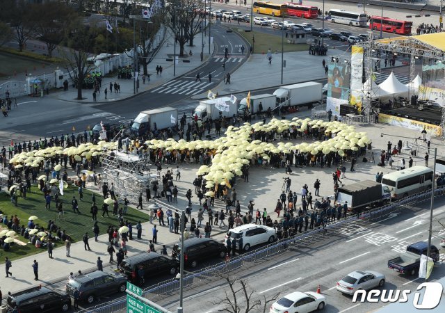 14일 오후 4시 16분에 서울 광화문광장에서 열린 세월호 참사 5주기 ‘잊지 않을게’ 대학생 대회에서 참가자들이 노란 우산으로 세월호 리본을 만드는 퍼포먼스를 하고 있다. 2019.4.13/뉴스1 © News1