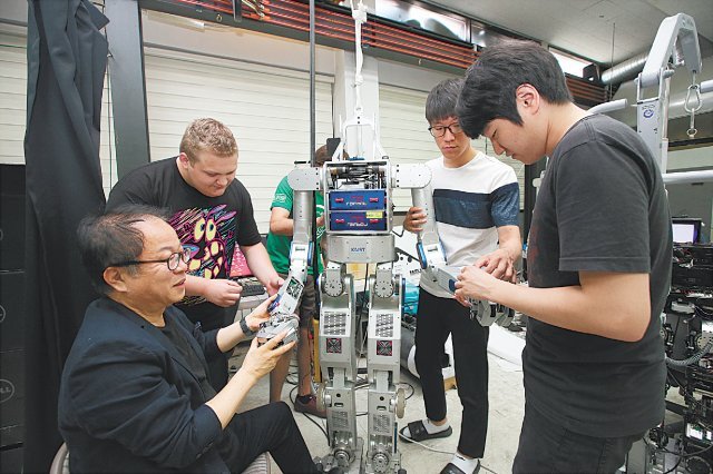 KAIST 오준호 교수가 휴보랩 연구실에서 학생과 로봇에 대한 토의를 하고 있다. KAIST 제공