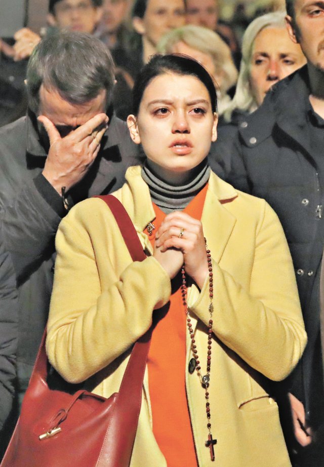 간절한 기도 15일(현지 시간) 프랑스 파리의 한 여성이 불길에 휩싸인 노트르담 대성당을 바라보며 묵주를 손에 쥔 채 안타까워하고 있다. 파리=AP 뉴시스