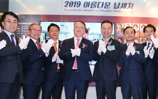한승희 국세청장(왼쪽에서 네 번째)은 17일 서울 종로구 서울지방국세청에서 성실 납세자 가운데 사회공헌도가 높은 24명을 선정해 아름다운 납세자상을 수여했다. 국세청 제공