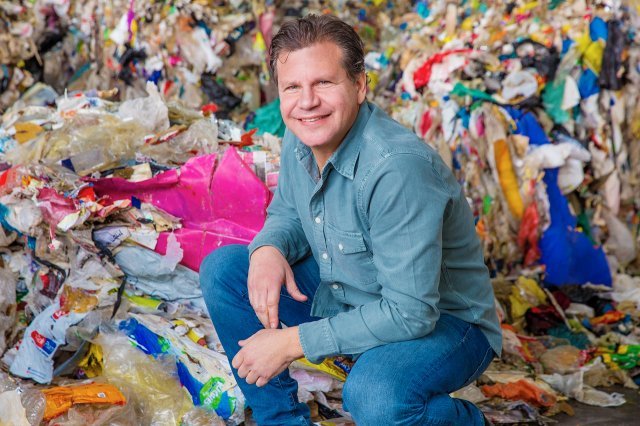 이스라엘 스타트업 UBQ의 창립자인 잭 비지오가 쓰레기더미 속에 앉아있다. 이 쓰레기는 UBQ의 공정을 거쳐 플라스틱으로 재활용될 예정이다. 사진 UBQ 제공