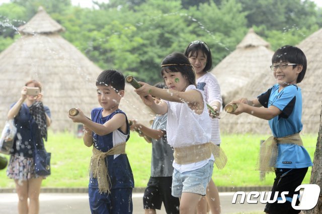 서울 강동구 암사동유적에서 신석기 분장을 한 어린이들이 대나무로 만든 물총으로 물싸움을 하고 있다. /뉴스1 © News1