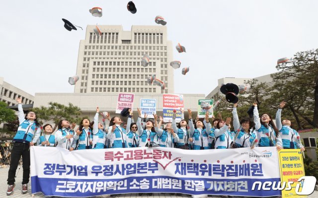 재택위탁집배원들이 23일 서울 서초동 대법원 앞에서 근로자지위확인 소송 대법원 판결 기자회견을 갖고 모자를 하늘로 던지며 승소의 기쁨을 만끽하고 있다. 2019.4.23/뉴스1 © News1