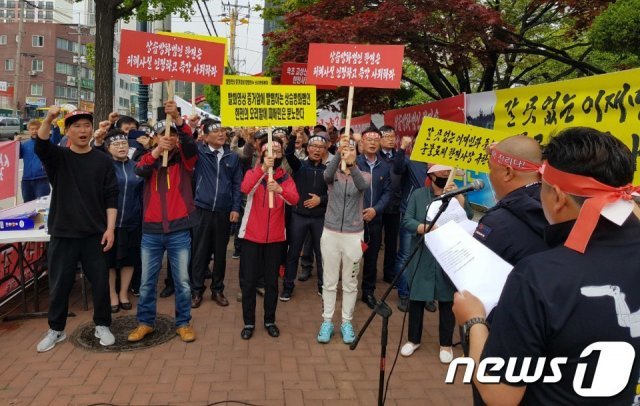 24일 한국전력공사 속초지사 앞에서 고성·속초지역 산불피해 이재민들이 손피켓을 들고 시위하고 있다.(독자제공) 2019.4.24/뉴스1 © News1