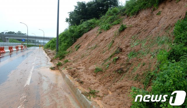 용인지역에 폭우로 인해 산사태주의보가 발령된 31일 오전 경기도 용인시 한 도로에 토사가 쏟아져 시 공무원들이 복구를 하고 있다. © News1