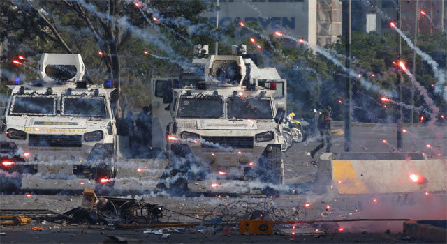 최루탄 난무하는 베네수엘라 지난달 30일 베네수엘라 수도 카라카스에서 니콜라스 마두로 대통령의 퇴진을 
요구하는 반정부 시위대와 이를 진압하는 국가수비대 사이에 충돌이 발생했다. 시위대를 진압하기 위해 거리에 등장한 두 대의 장갑차 
사이로 포탄이 난무하고 있다. 카라카스=AP 뉴시스