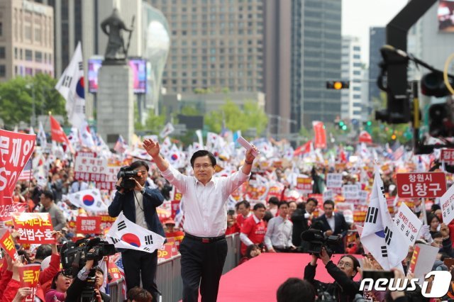 황교안 자유한국당 대표가 지난달 27일 오후 서울 종로구 세종문화회관 앞에서 열린 ‘문재인 정권의 국정운영 규탄 2차 장외집회’에서 연설을 위해 단상으로 향하며 두손을 번쩍 들고 있다. 2019.4.27/뉴스1 © News1