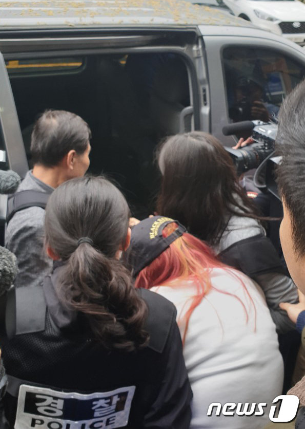 30대 남성이 10대 의붓딸을 살해하고 시신을 유기한 사건과 관련해 지난 30일 오전 광주 동부경찰서에서 범행에 공모한 것으로 드러난 친모(가운데)가 긴급체포돼 압송되고 있다.2019.4.30/뉴스1