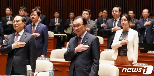 이해찬 더불어민주당 대표와 홍영표 원내대표를 비롯한 더불어민주당 의원들이 29일 서울 여의도 국회 예산결산특별위원회 회의장에서 열린 의원총회에서 국민의례를 하고 있다. 2019.4.29/뉴스1 © News1