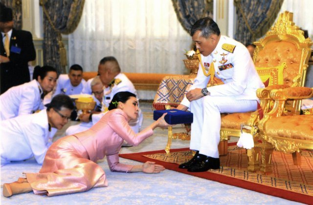 1일(현지 시간) 태국 방콕 왕궁에서 열린 마하 와치랄롱꼰 국왕(오른쪽)과 수티다 와찌랄롱꼰 나 아유타야 근위대장의 결혼식 장면. 왕이 엎드린 왕비에게 전통 예물을 건네고 있다. 방콕=AP 뉴시스