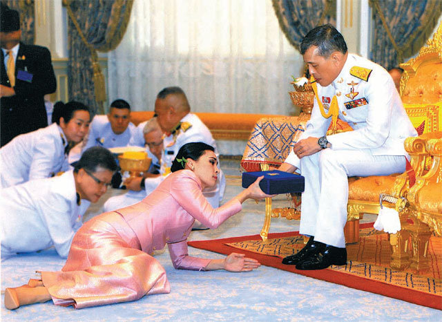 1일(현지 시간) 태국 방콕 왕궁에서 열린 마하 와치랄롱꼰 국왕(67·오른쪽)과 수티다 와찌랄롱꼰 나 아유타야 근위대장(41)의 결혼식 장면. 왕이 바닥에 엎드려 예물을 바친 왕비에게 답례 예물을 건네고 있다. 와치랄롱꼰 왕의 결혼은 이번이 네 번째다. 방콕=AP 뉴시스