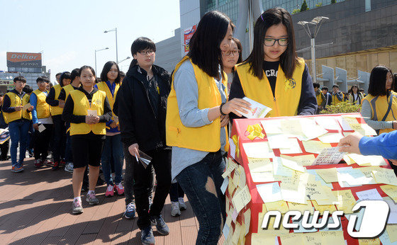 샤프론 봉사단 학생들이 서울 청량리역 광장에서 열린 미아·실종아동 찾기 및 세월호 희생자 추모행사에서 안전하고 행복한 세상을 추구하는 소망편지를 작성해 우체통에 넣고 있다. 2014.5.5/뉴스1