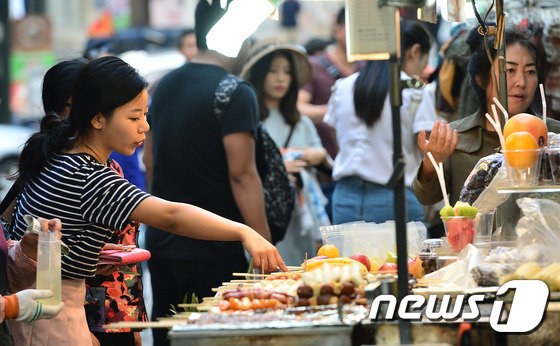 서울 중구 명동을 찾은 중국인 관광객들이 길거리 음식을 둘러보고 있다. © News1