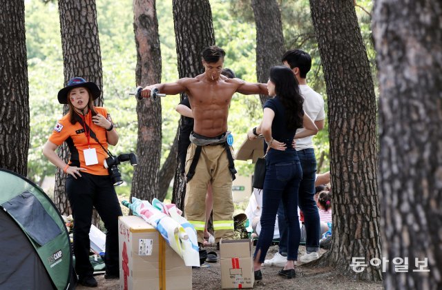 경기 시작 전 여의도공원 나무숲에서 아령을 들어올리며 몸을 만들고 있다.