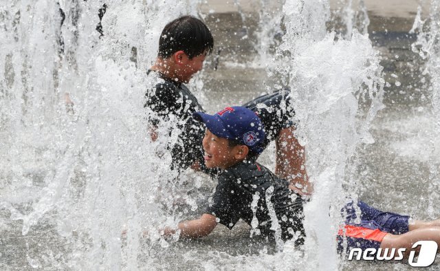 한낮 기온이 30도 가까이 오르는 등 초여름 날씨를 보인 12일 서울 광화문광장 분수대에서 어린이들이 물놀이를 하고 있다. 2019.5.12/뉴스1 © News1
