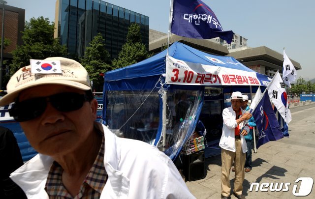 대한애국당 당원들이 11일 서울 광화문광장에 설치한 천막 앞에서 구호를 외치고 있다. © News1
