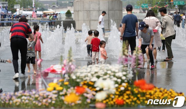 한낮 기온이 30도 가까이 오르는 등 초여름 날씨를 보인 12일 서울 광화문광장 분수대에서 어린이들이 물놀이를 하고 있다. © News1
