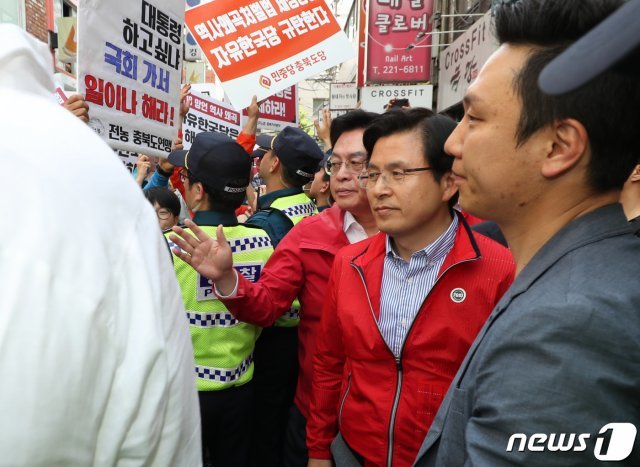 황교안 자유한국당 대표가 14일 오후 충북 청주시 상당구의 한 카페에서 청주시학교운영위원협의회와 간담회를 마친 뒤 자리를 떠나고 있다. 이날 간담회장 앞에서 민주노총 충북본부 소속 회원들이 기습 시위를 벌였다. 2019.5.14/뉴스1 © News1