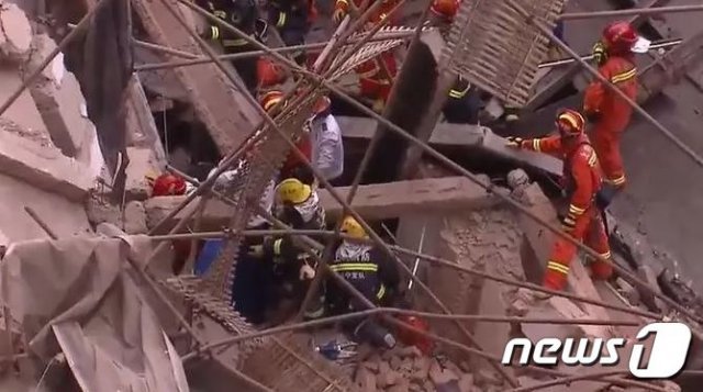 상하이 중심가에서 보수 공사중이던 건물이 붕괴돼 구조대원들이 매몰된 이들을 구출하고 있다. <출처=칸칸뉴스> © 뉴스1