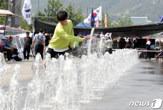 서울 도심의 낮 기온이 30도까지 오르며 초여름 날씨를 보인 16일 오후 세종대로 광화문광장 분수대에서 한 학생이 더위를 식히고 있다. 2019.5.16/뉴스1 © News1 이재명 기자