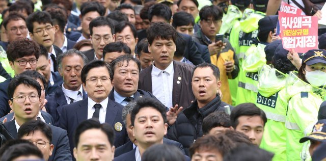 퇴장하는 황교안
자유한국당 황교안 대표가 18일 오전 광주 국립5·18민주묘지에서 열린 제39주년 5·18 민주화운동 기념식을 마치고 시민들의 항의를 받으며 차량으로 이동하고 있다. 송은석 기자 silverstone@donga.com